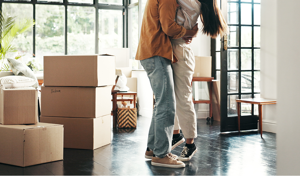 couple hugging, surrounded by moving boxes